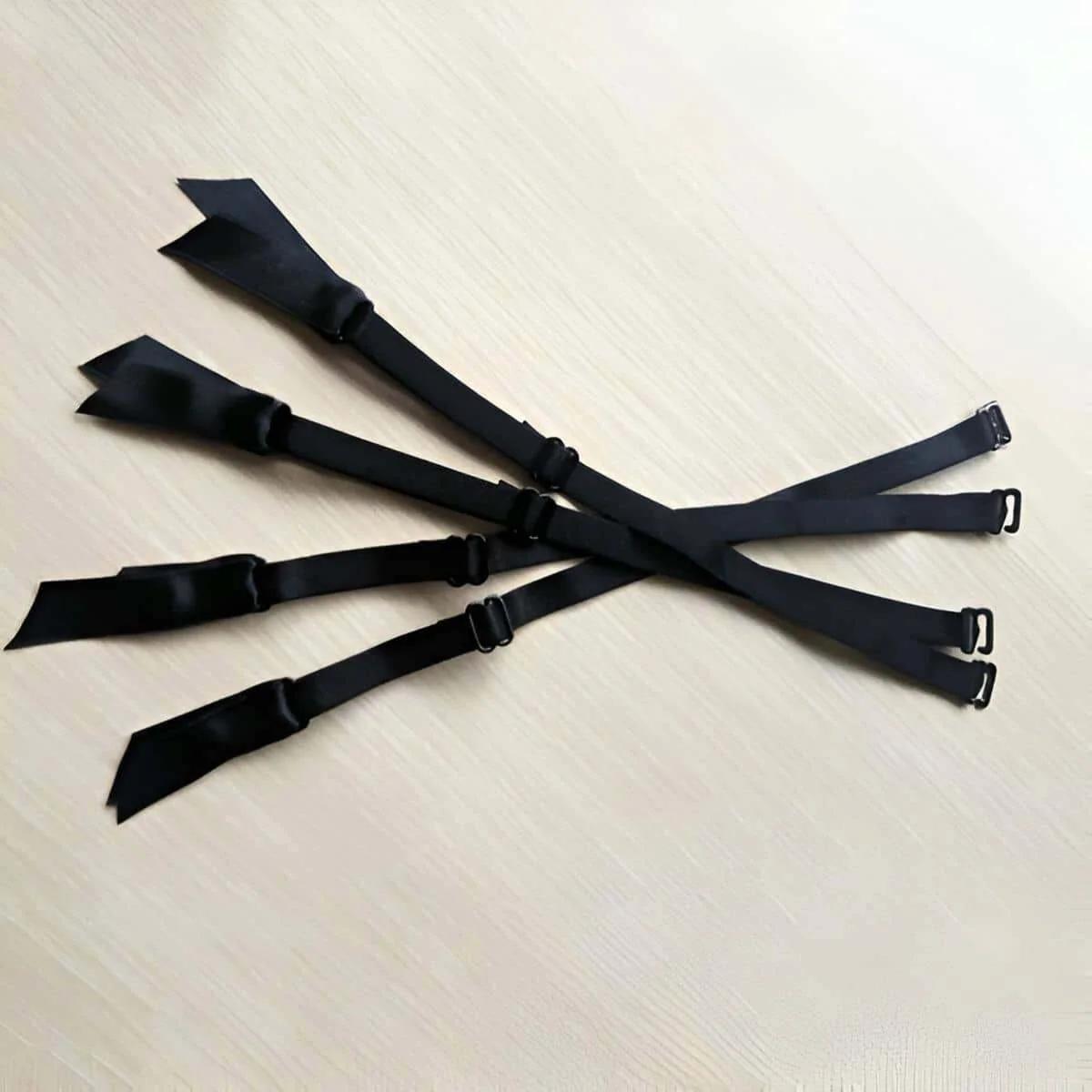 black adjustable elastic garter straps 4 pack with matte metal clip hooks laid flat on light surface